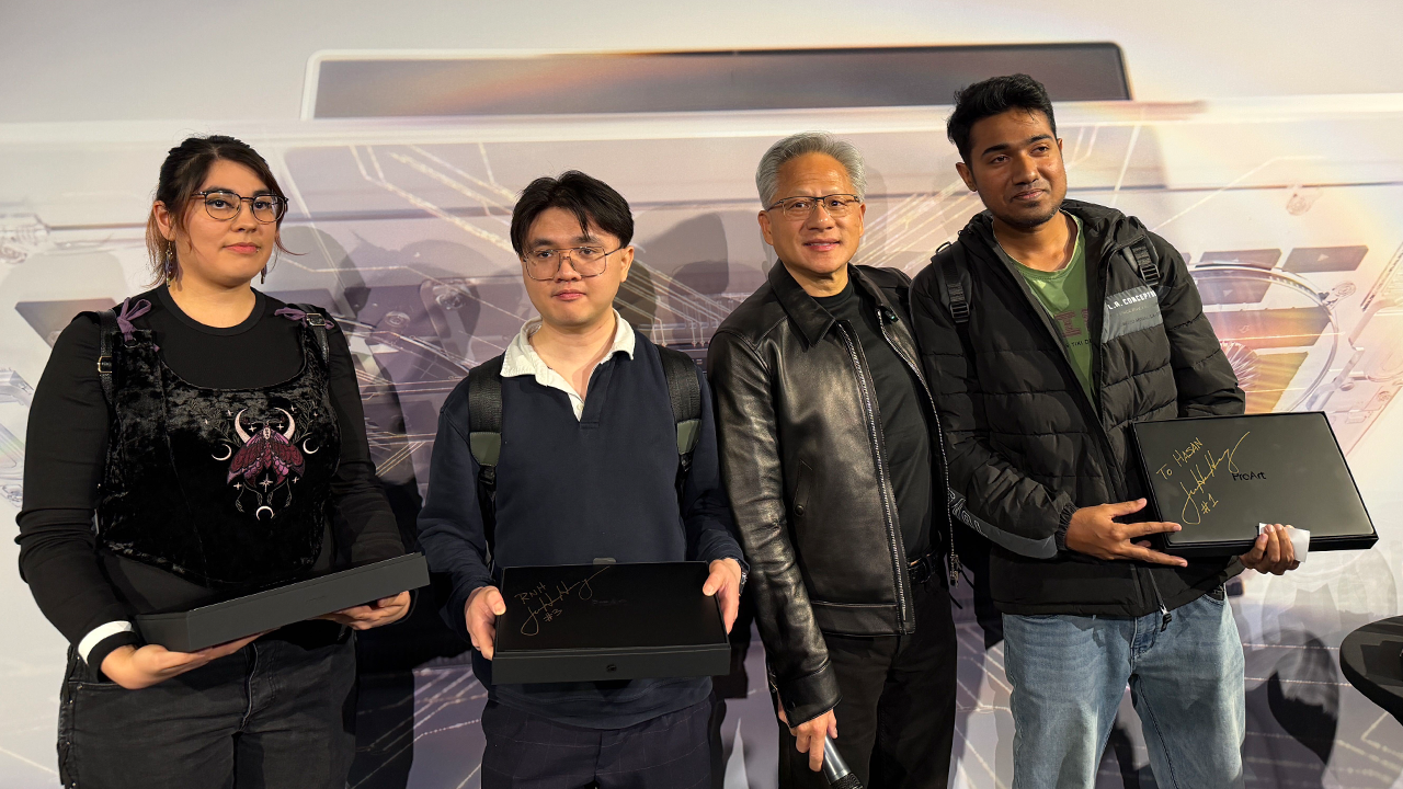ผู้คนถืออุปกรณ์ RTX Spark ที่เซ็นชื่อ ชายสวมเสื้อหนังคล้าย Jensen Huang